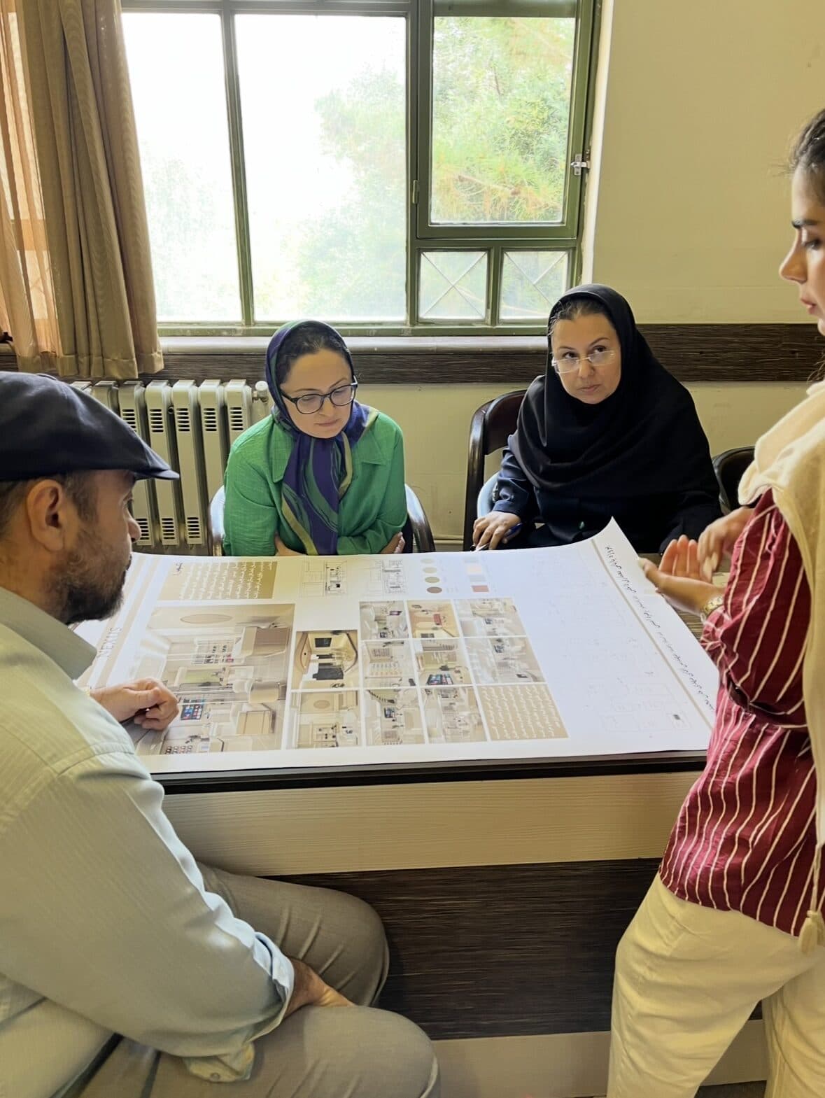 Dr Shida Changizi reviewing architectural drawings with colleagues